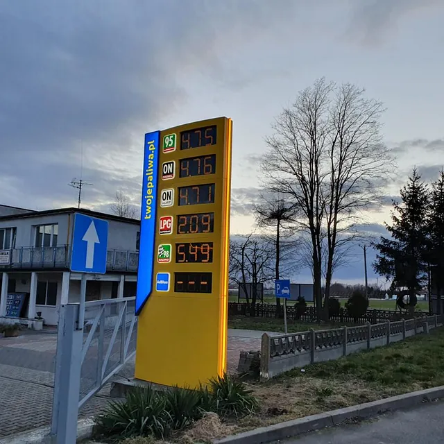 Żółty pylon cenowy na stacji paliw
