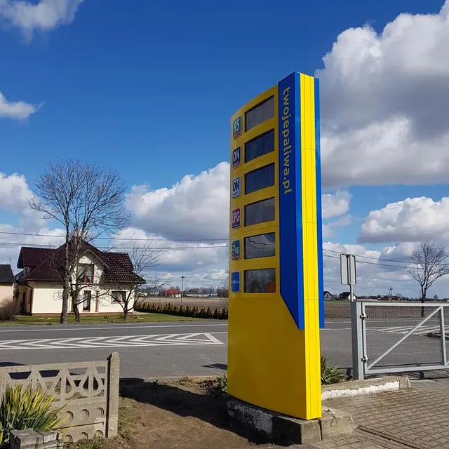 Żółty pylon cenowy przy stacji paliw