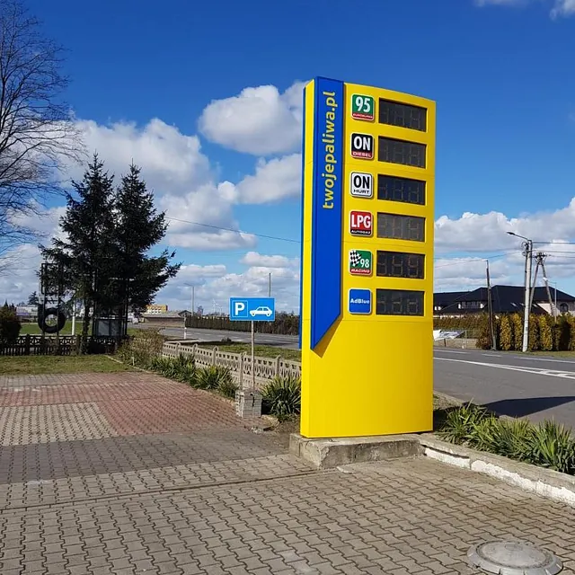 Żółty pylon cenowy na stacji paliw