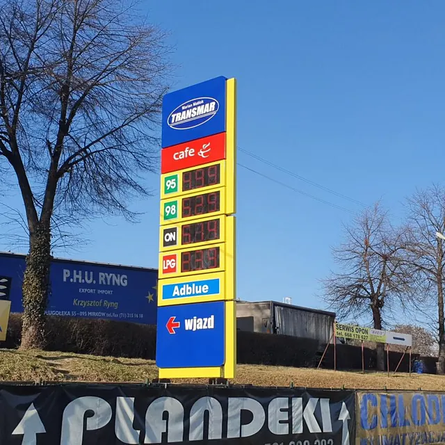 Żółty pylon cenowy na stacji paliw