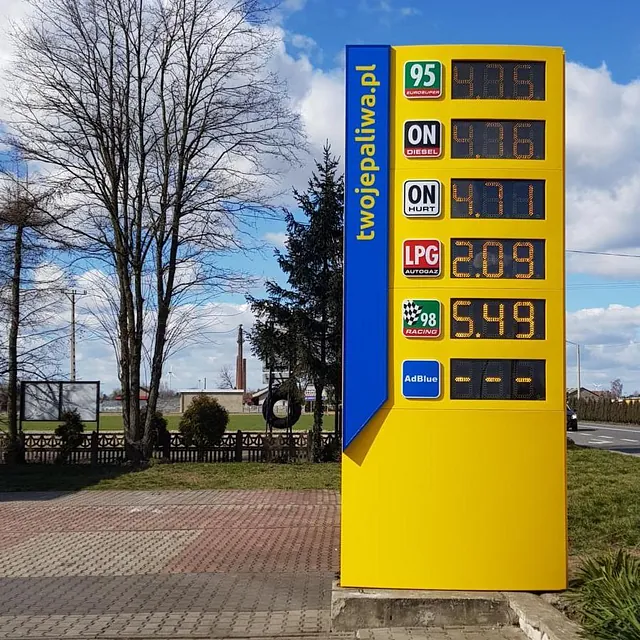 Żółty pylon cenowy na stacji paliw